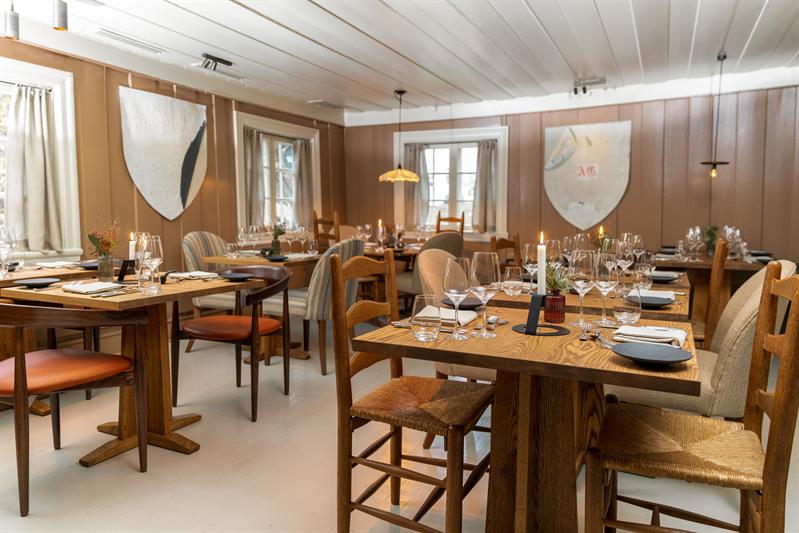Hovedstuen på Vertshusest, dekket bord og stoler i tre