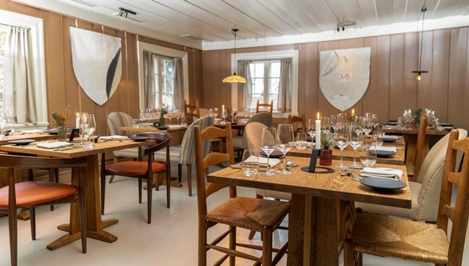 Hovedstuen på Vertshusest, dekket bord og stoler i tre