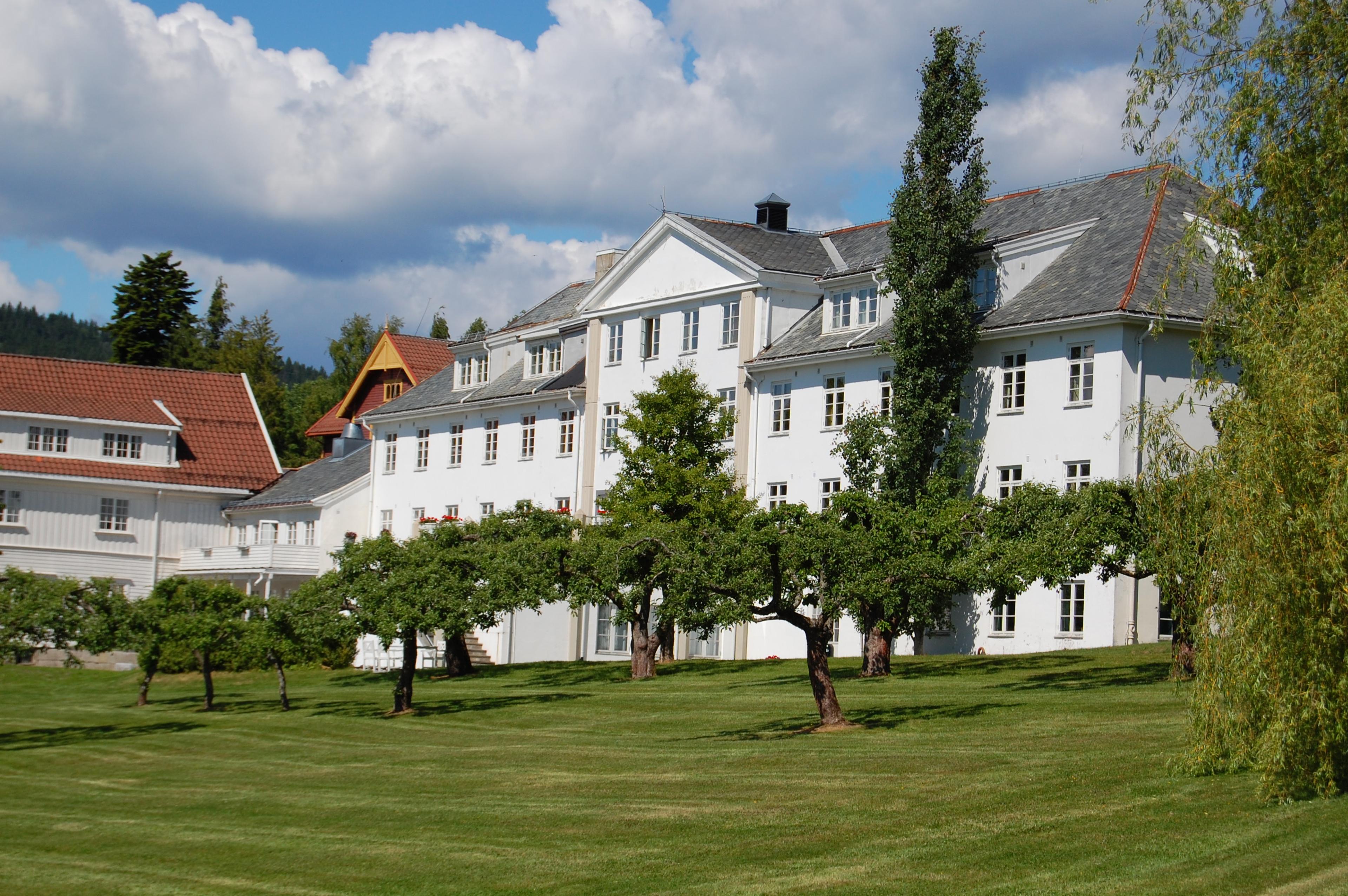 Øvre sem gård - hvit gårdsbygning i 3 etasjer - grønn plen