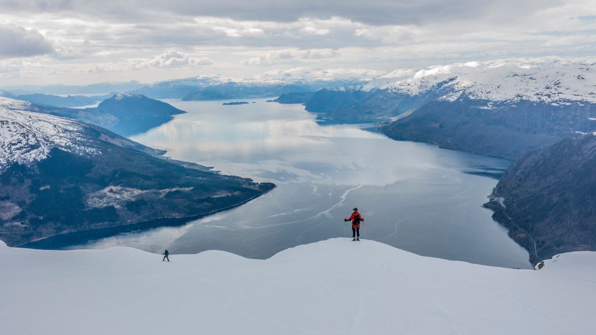 Snowshoers enjoying panoramic views of fjords and snow-covered mountains.