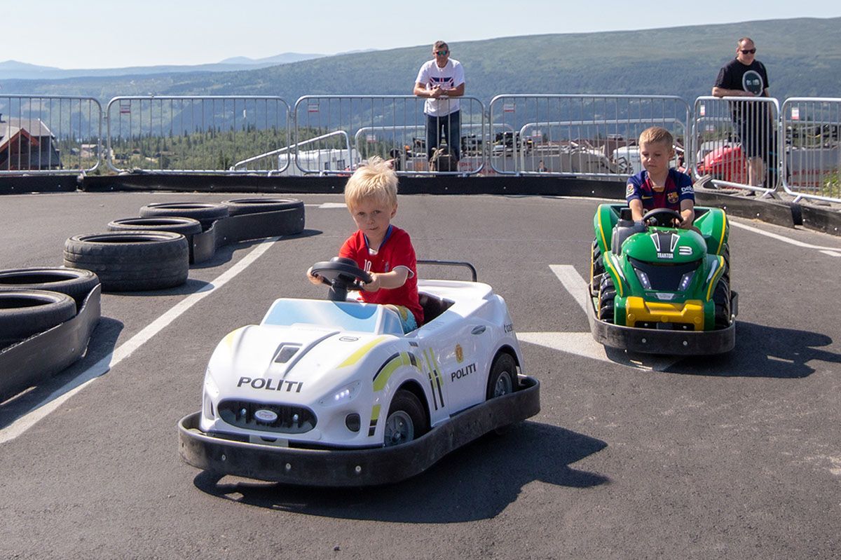 Barn i små elektriske biler på asfaltbane på beitostølen.