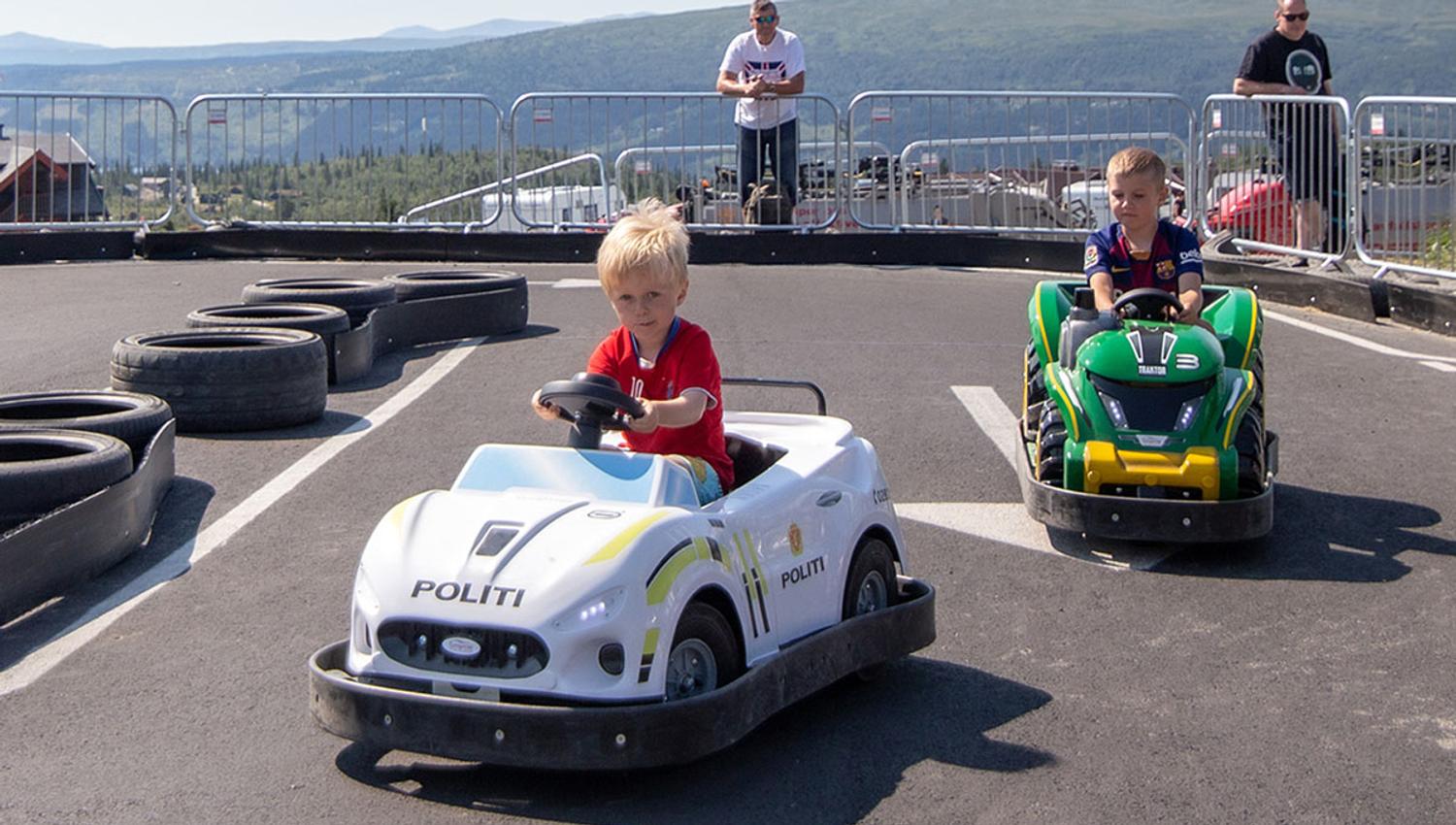 Barn i små elektriske biler på asfaltbane på beitostølen.
