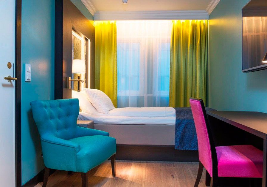 room with bed, armchair and desk in bright colours