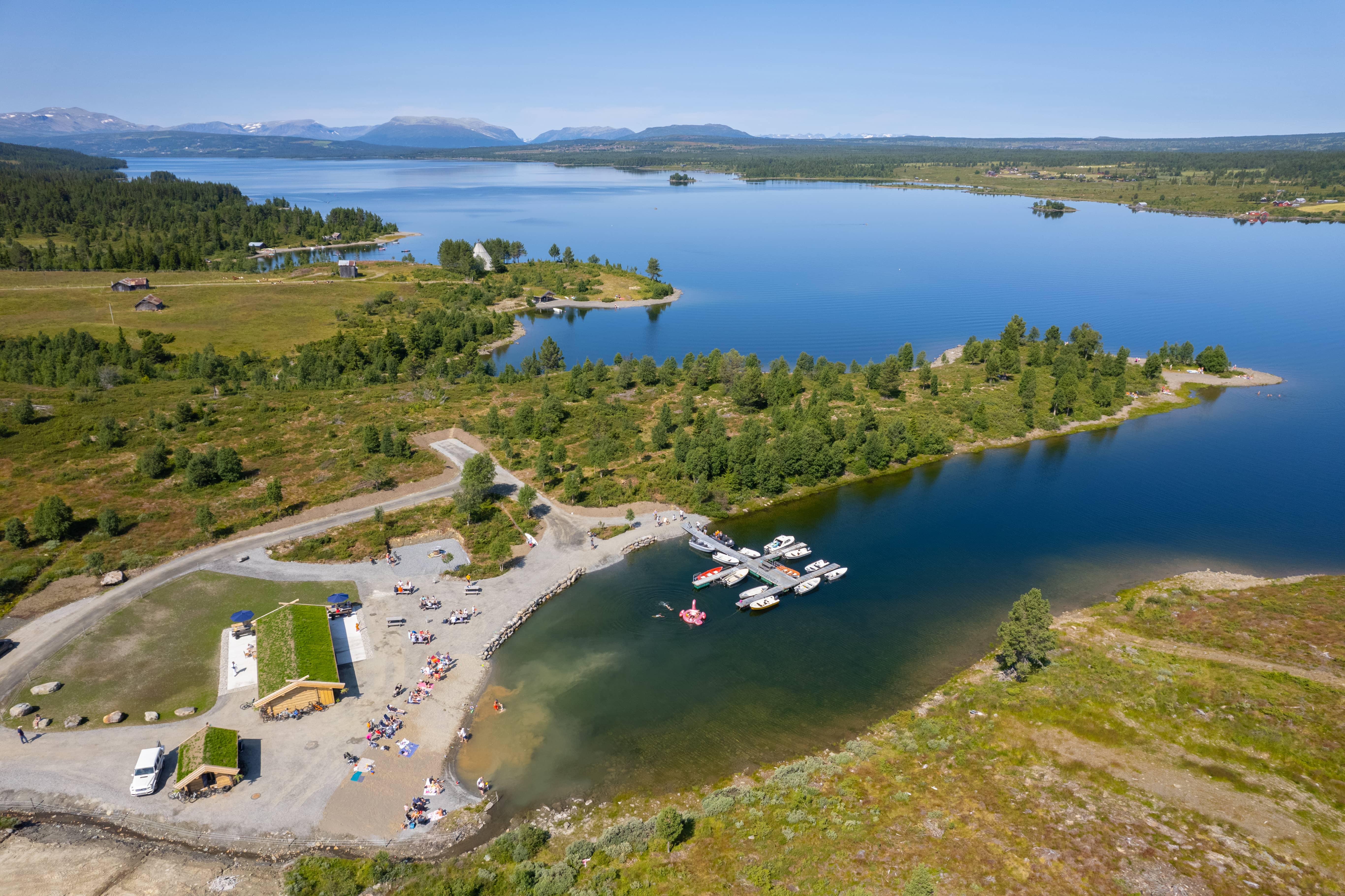 Utsikt over Vasskanten Marina med sandstrand, kafé og brygge
