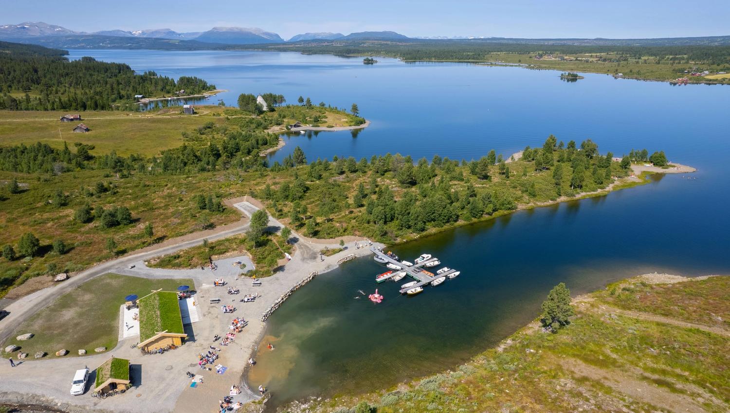 Utsikt over Vasskanten Marina med sandstrand, kafé og brygge