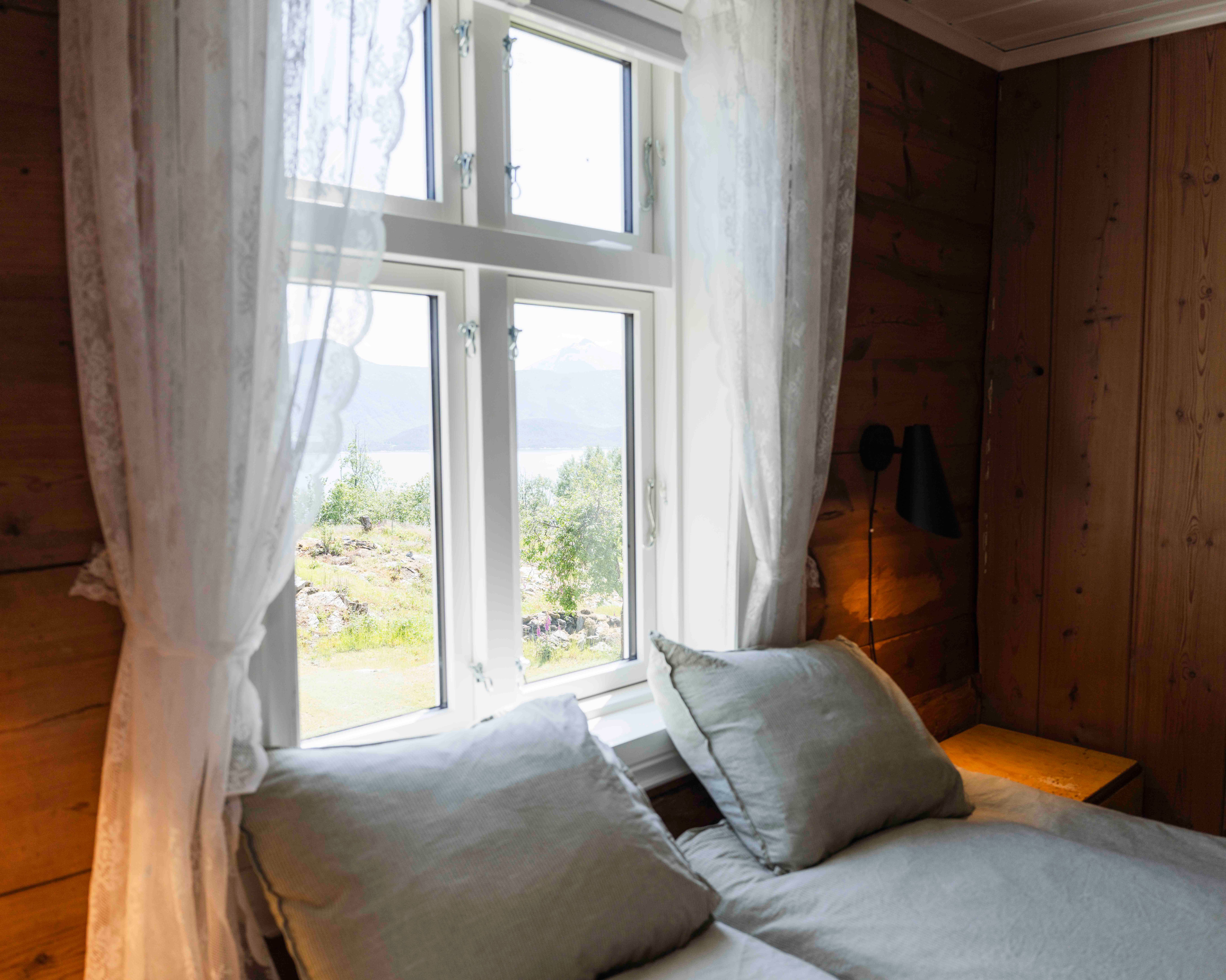 Soverom med fjordutsikt og morgonlys på Stigen Fjordlodge i Hardanger.