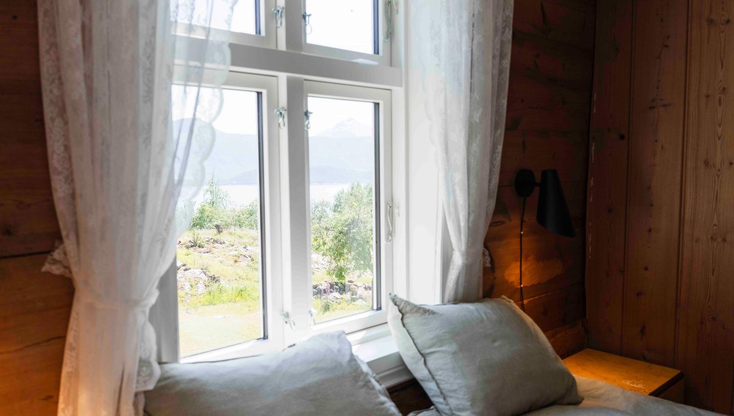 Soverom med fjordutsikt og morgonlys på Stigen Fjordlodge i Hardanger.