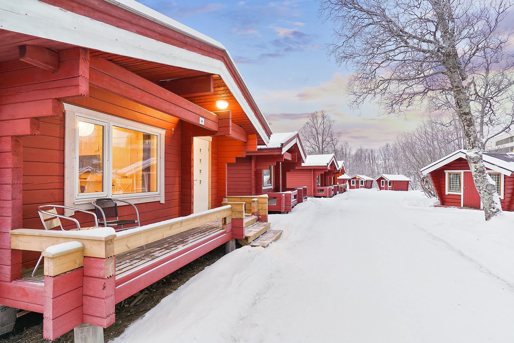 Red cabins along a snow-covered path