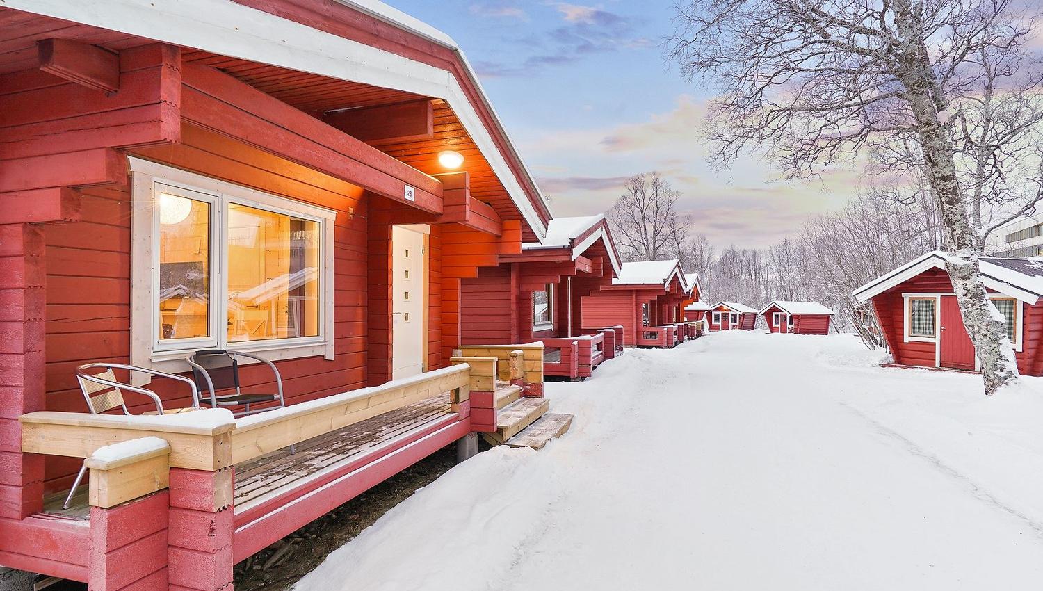 Red cabins along a snow-covered path