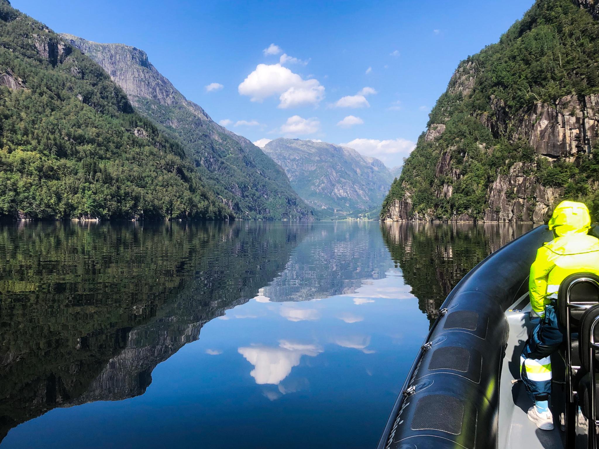 Spegelblank fjord omgitt av majestetiske fjell, sett frå ein RIB-båt på Norheimsund RIB Seafari i Hardanger.