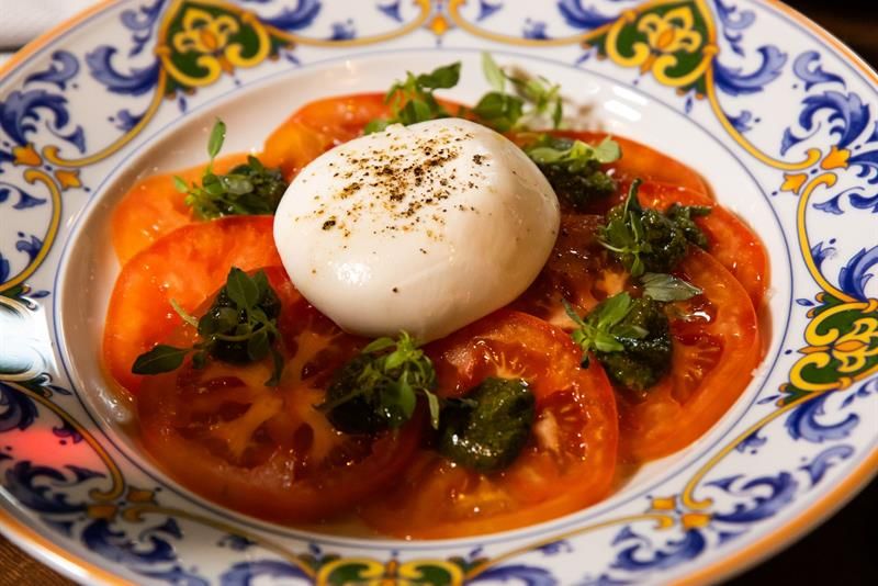Detalj av mozarella på en seng av tomatskiver på en tallerken
