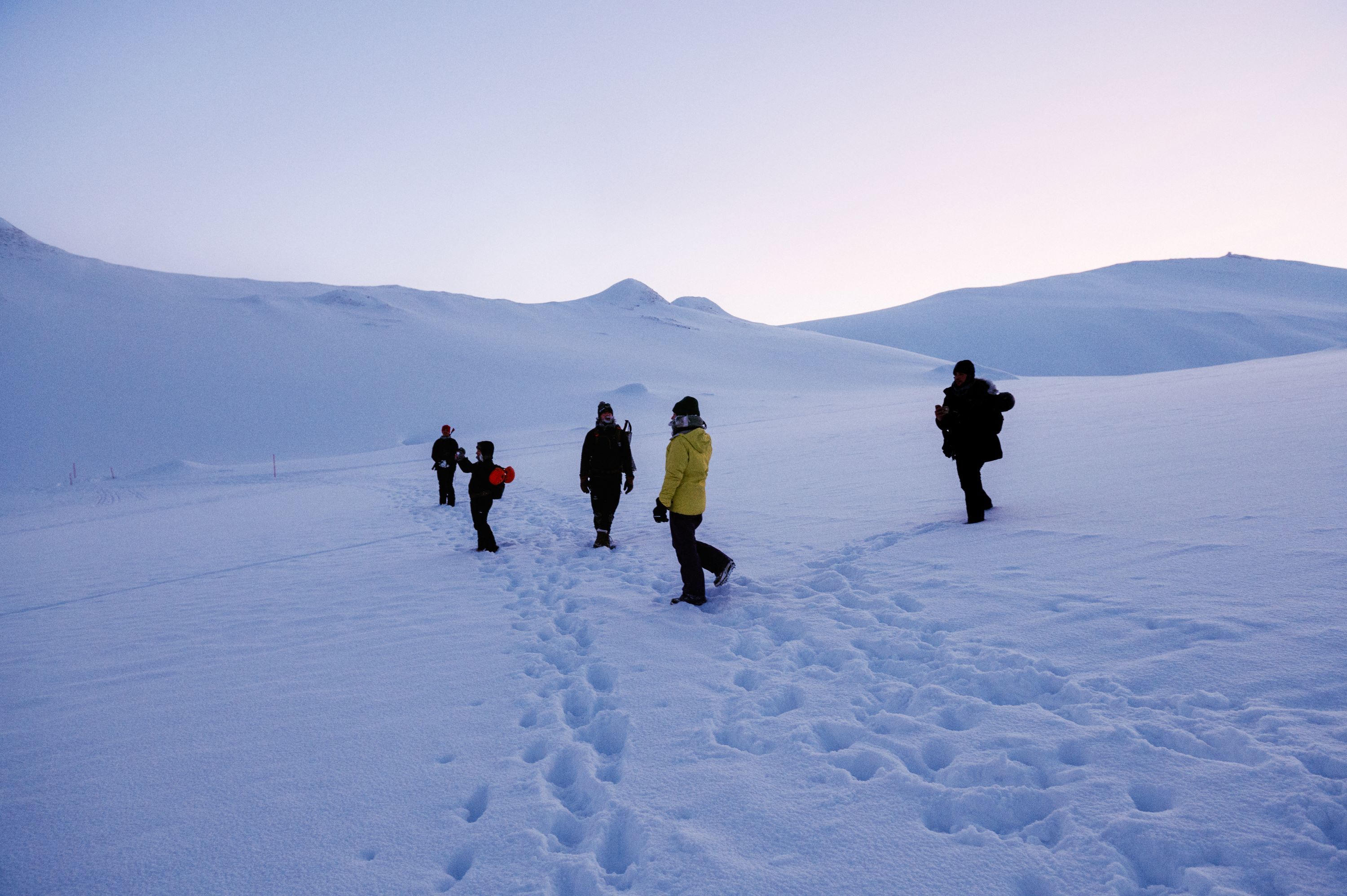 A group of people walking in a snow covered landscape