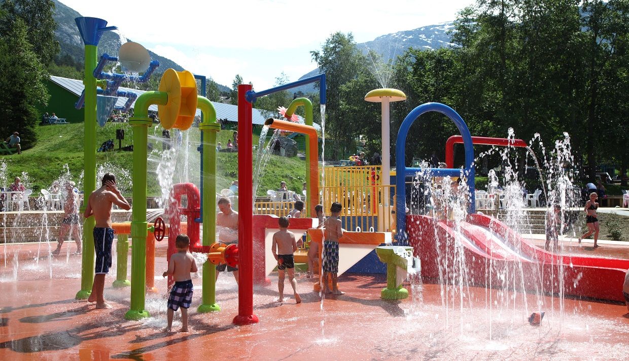Children playing in the colorful water play area at Mikkelparken