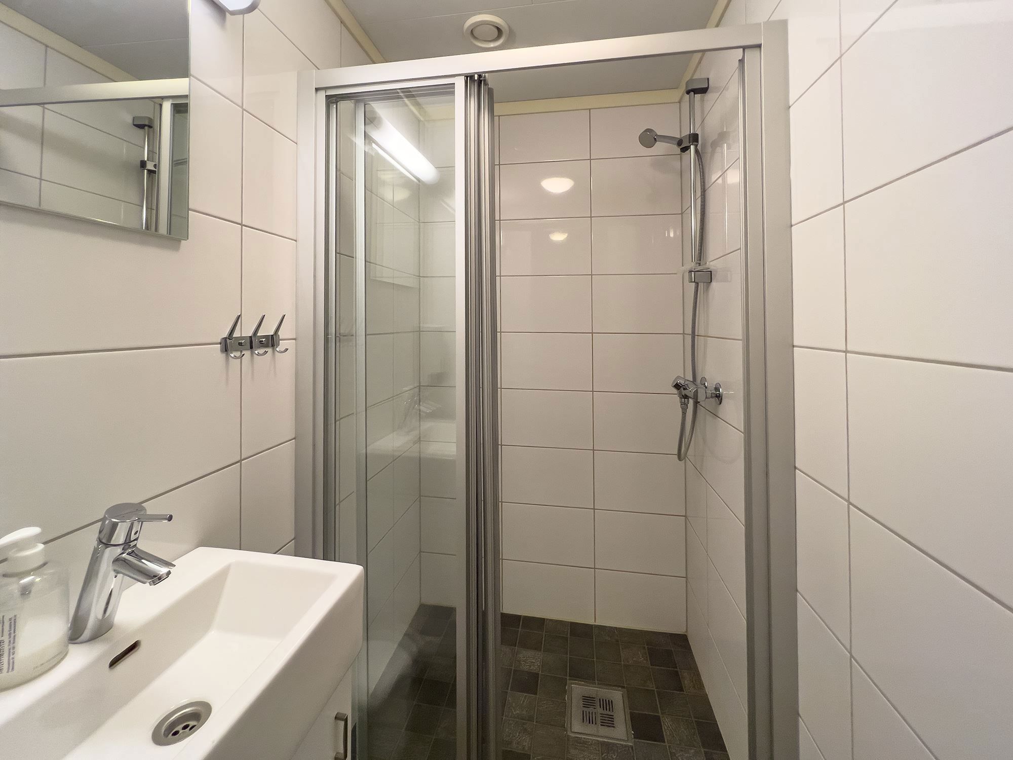 A bathroom with shower and sink.