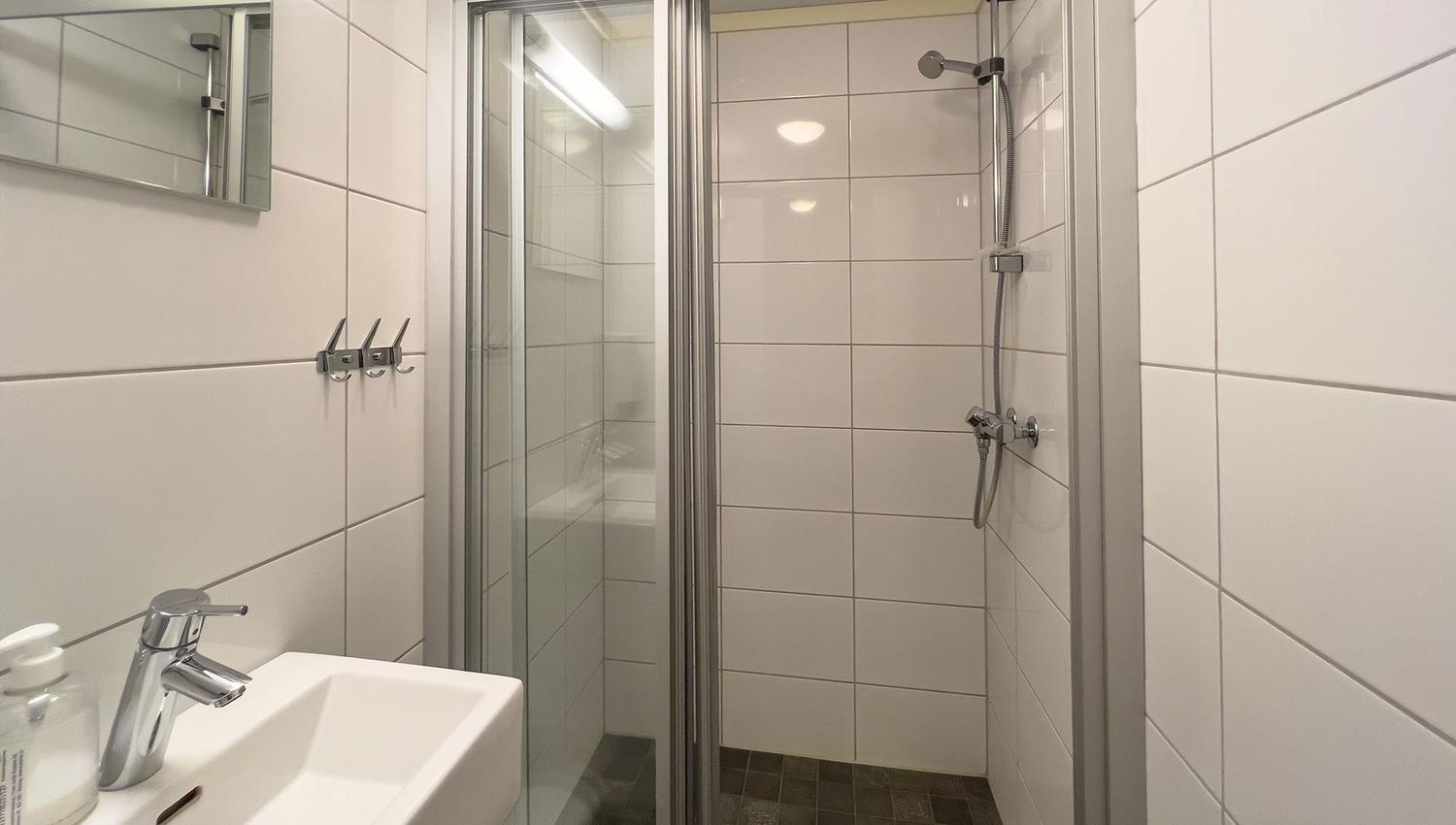 A bathroom with shower and sink.