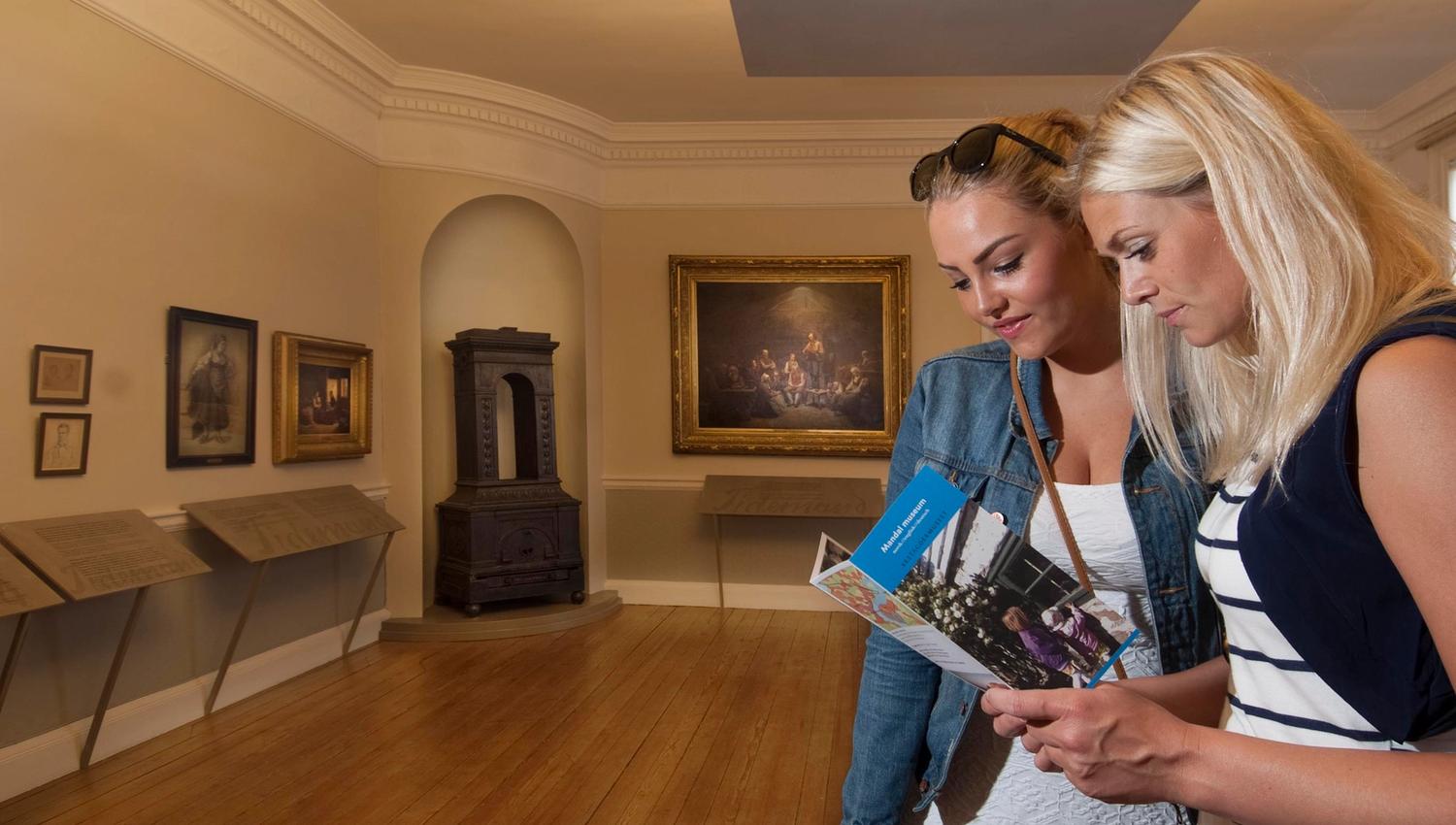 Et par som ser i Mandal museum sin brosjyre