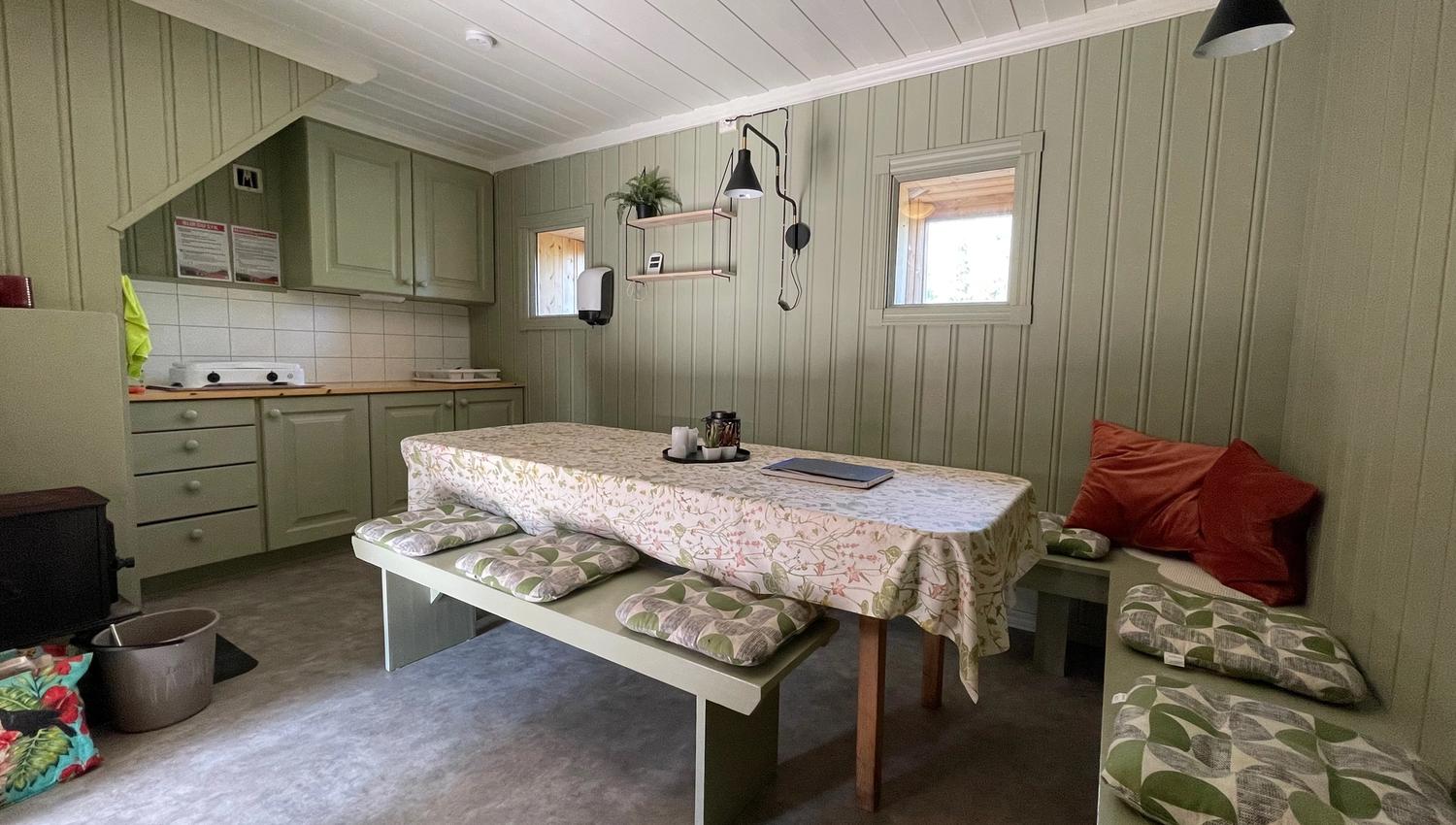 kjøkken med benk langs veggene og bord