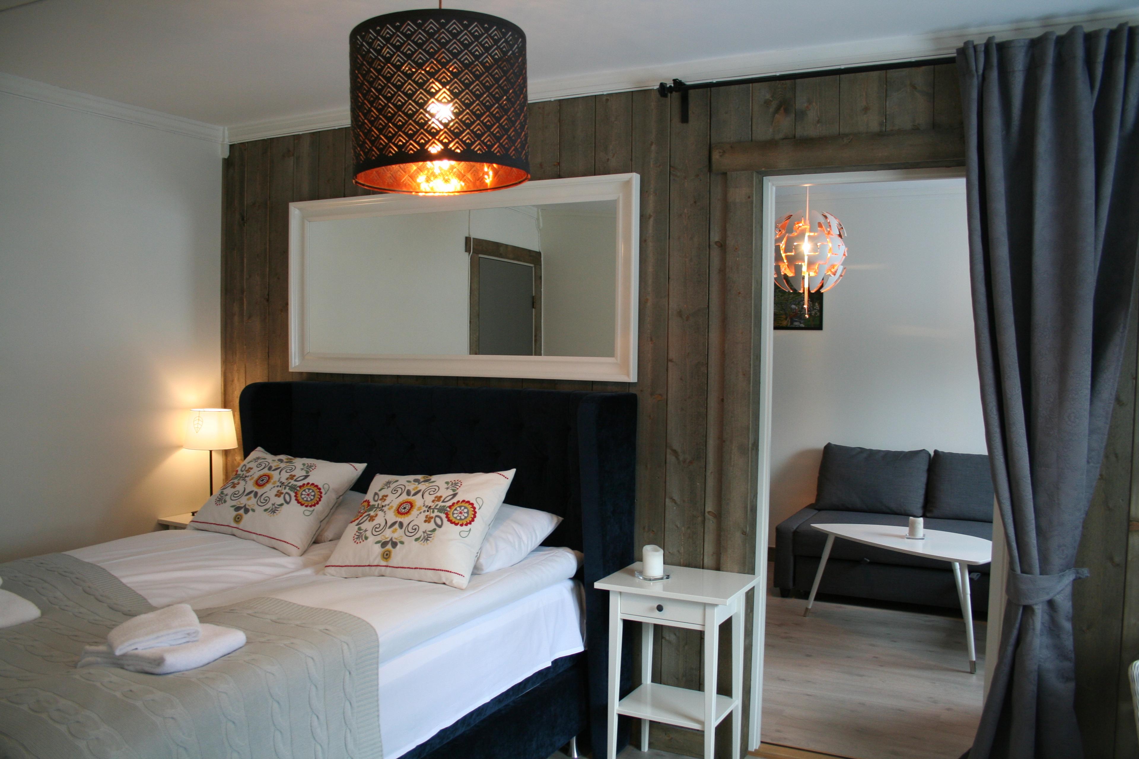 Moderne og innbydande rom på Kvamseter Lodge i Hardanger, med dobbeltseng og eigen sitjegruppe.