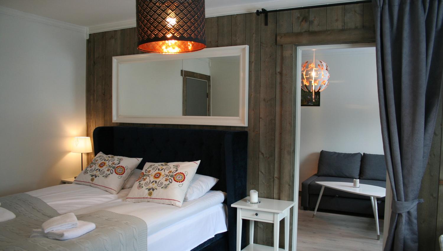 Moderne og innbydande rom på Kvamseter Lodge i Hardanger, med dobbeltseng og eigen sitjegruppe.