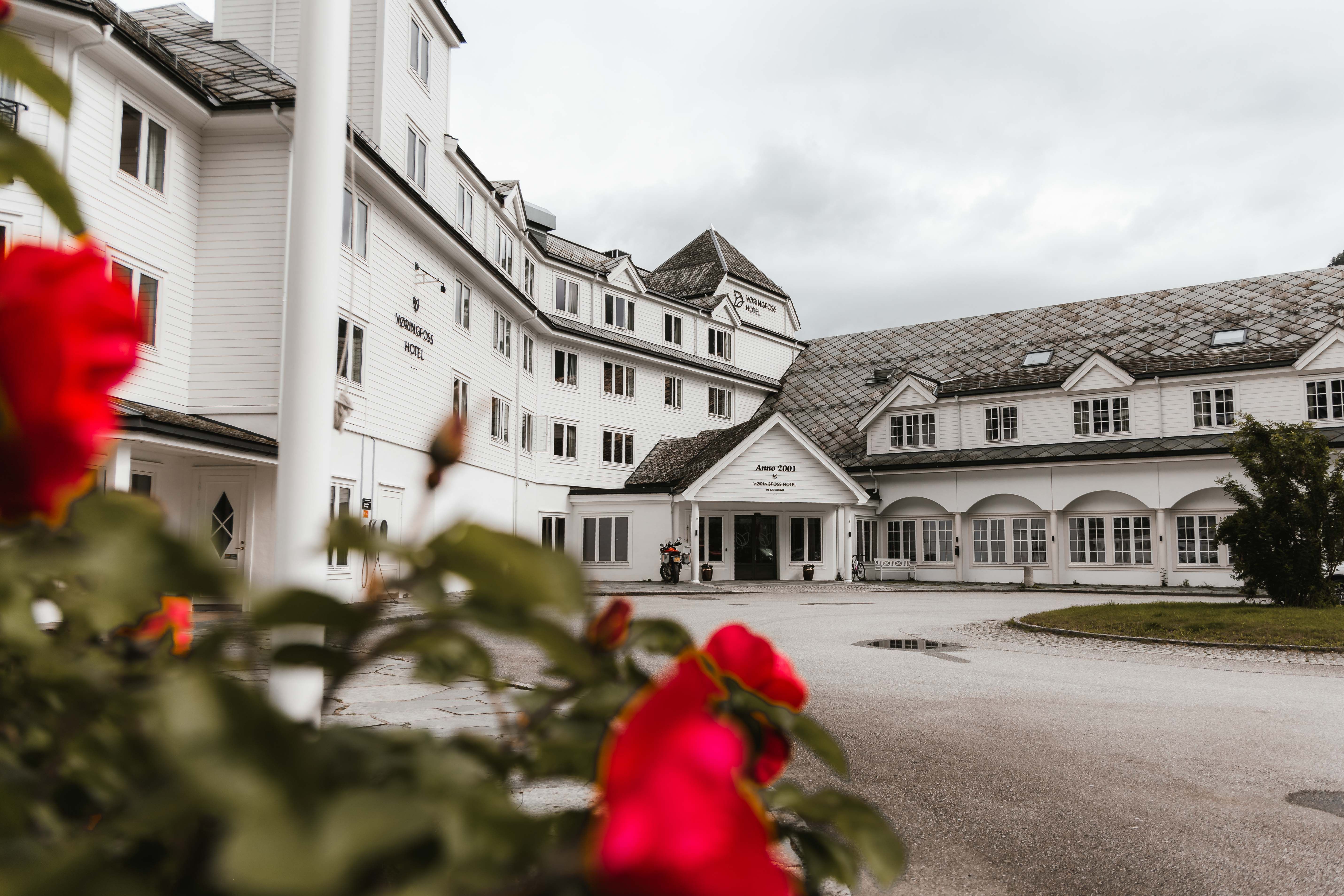 Vøringfoss Hotel sett fra utsiden, med noen blomster i forgrunnen.