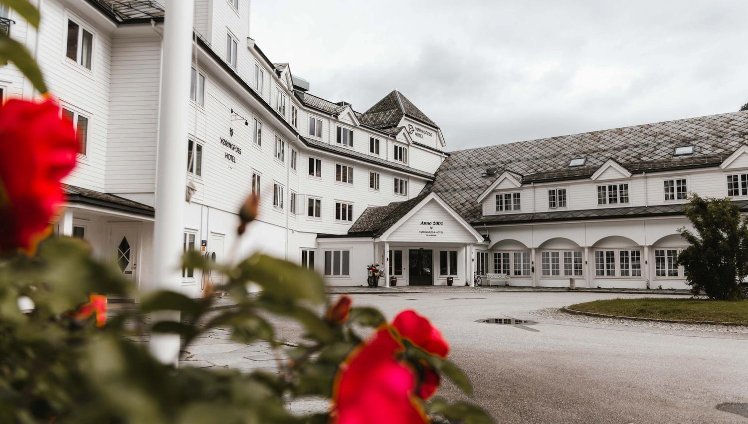 Vøringfoss Hotel sett fra utsiden, med noen blomster i forgrunnen.