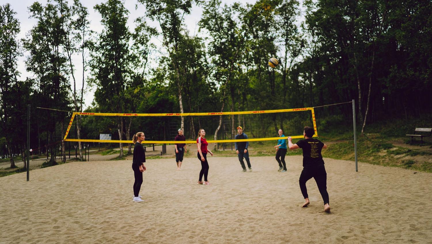 a group of friends playing sand volleyball