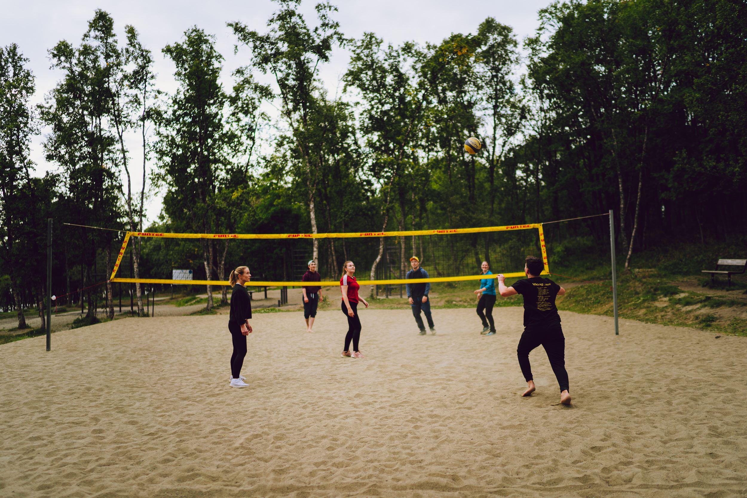 a group of friends playing sand volleyball