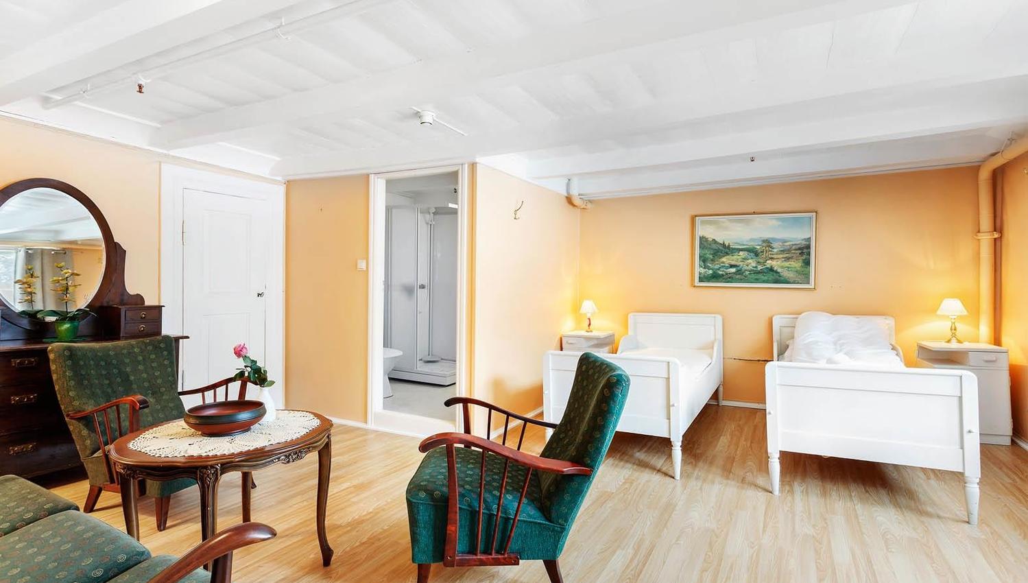 Room with twin beds and sitting area at Jaunsen Guesthouse in Hardanger.