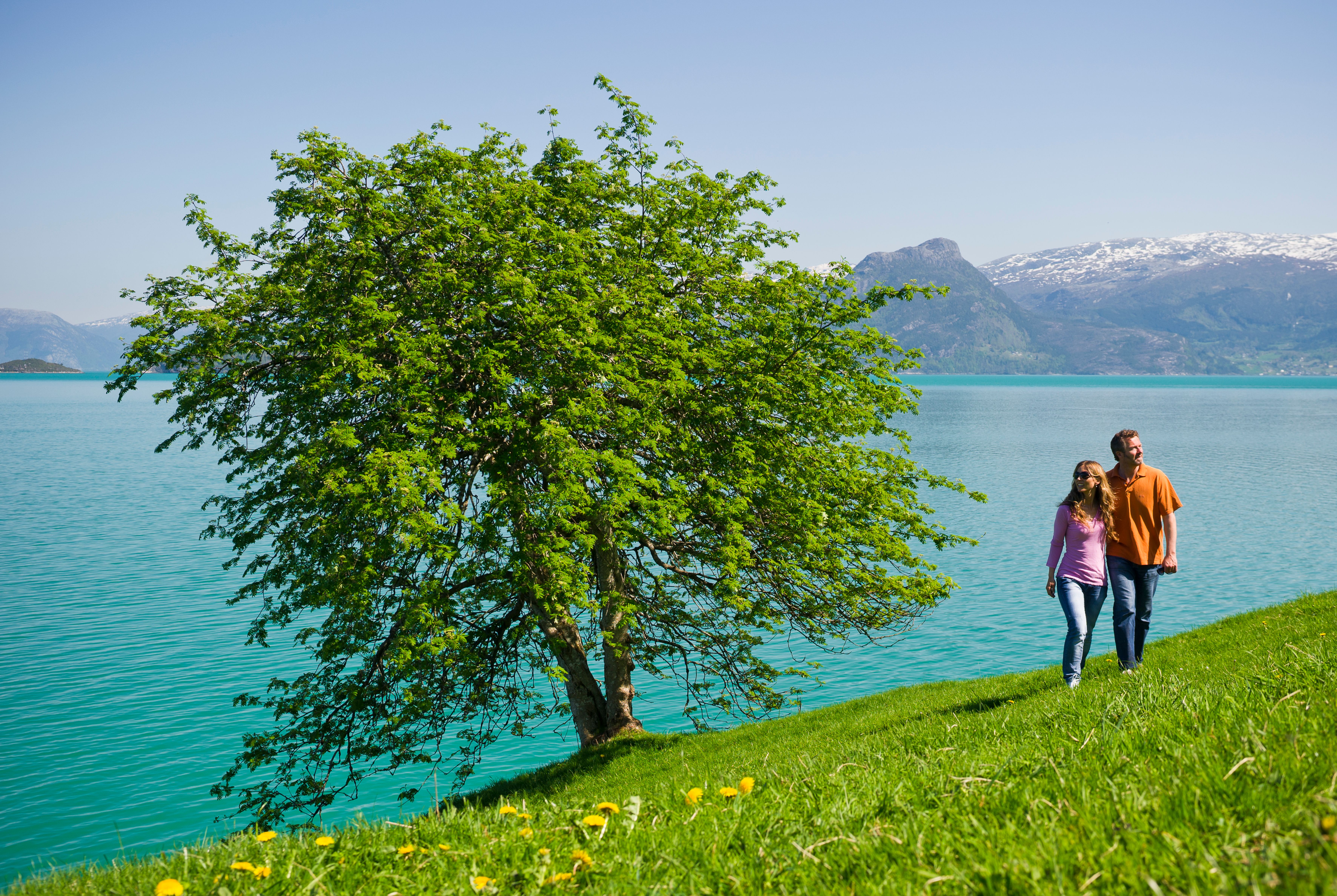 Par på tur ved Hardangerfjorden nær Oddland Camping ein solrik dag.