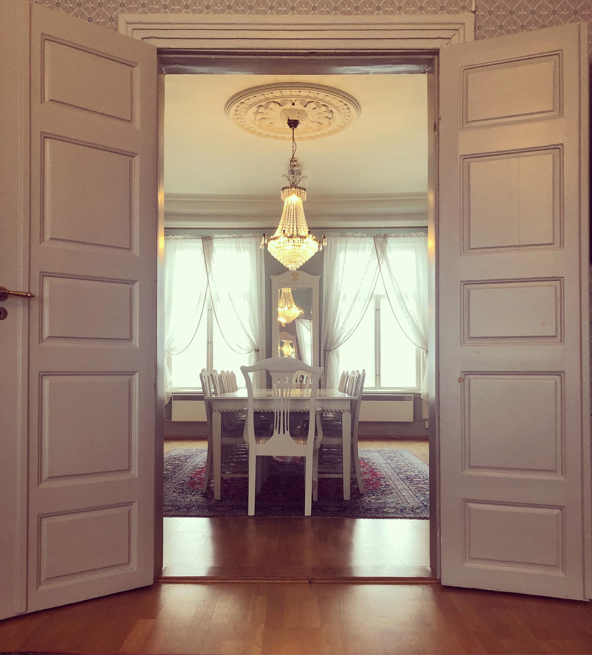 Selskapslokale med lysekrone og dekket bord