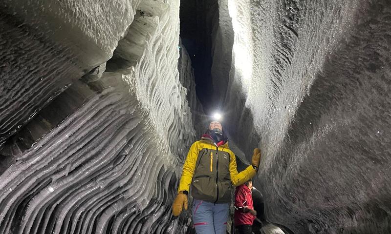 En person som beundrer formasjonene i isgrotten