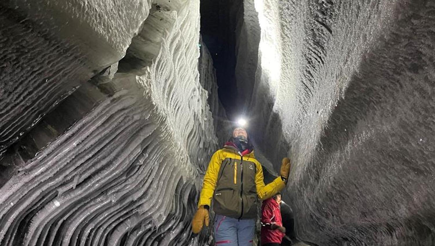 En person som beundrer formasjonene i isgrotten