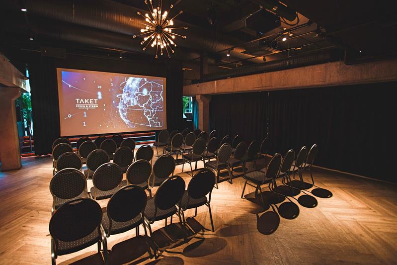 konferansesal med stoler og et stort lerret