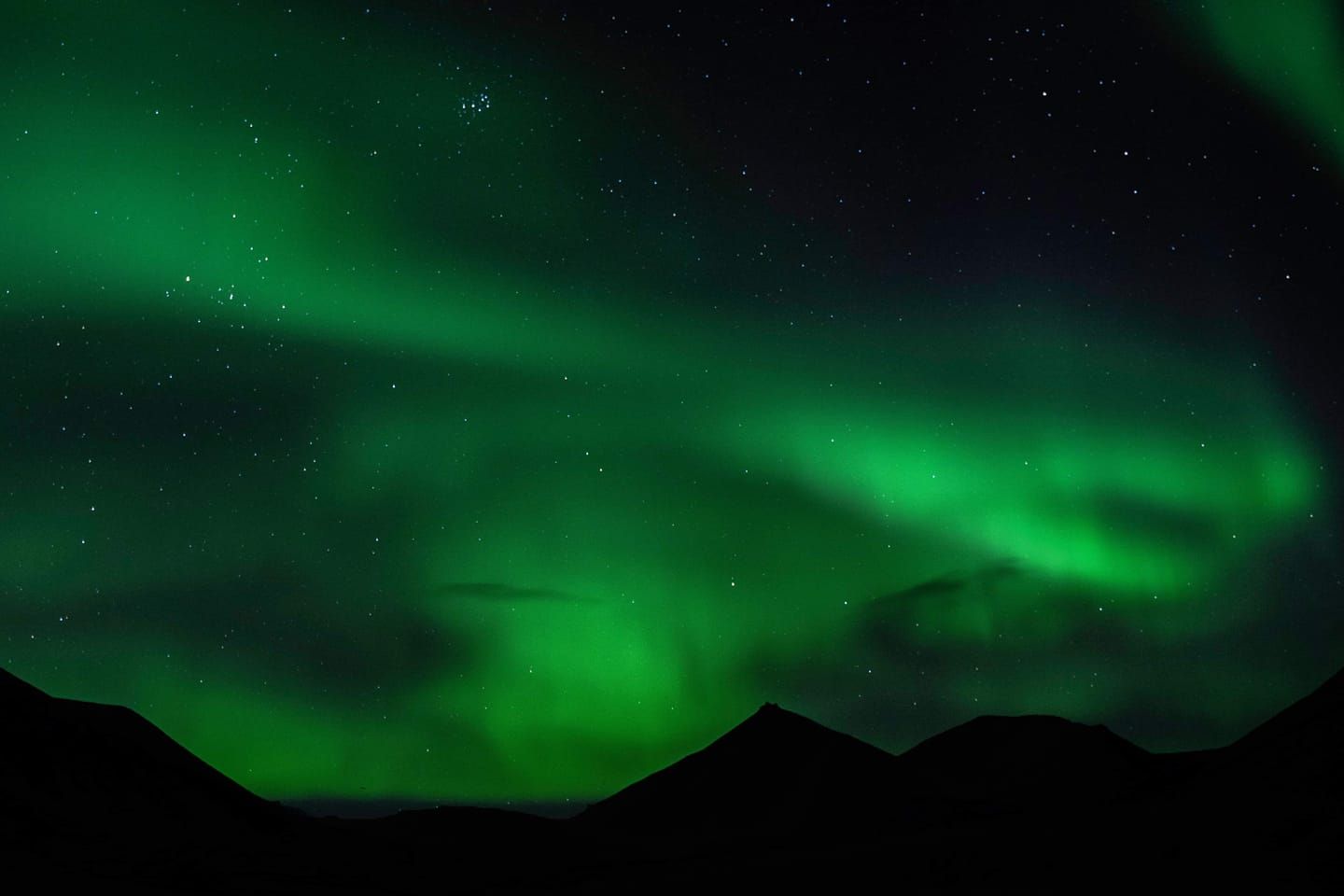 Nordlys som skinner over fjell