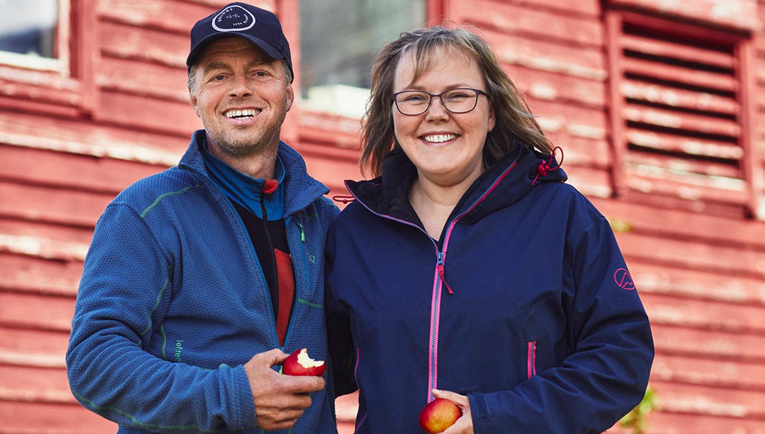 Vertskapet på Helleland Gard, smilande med friske epler frå garden.