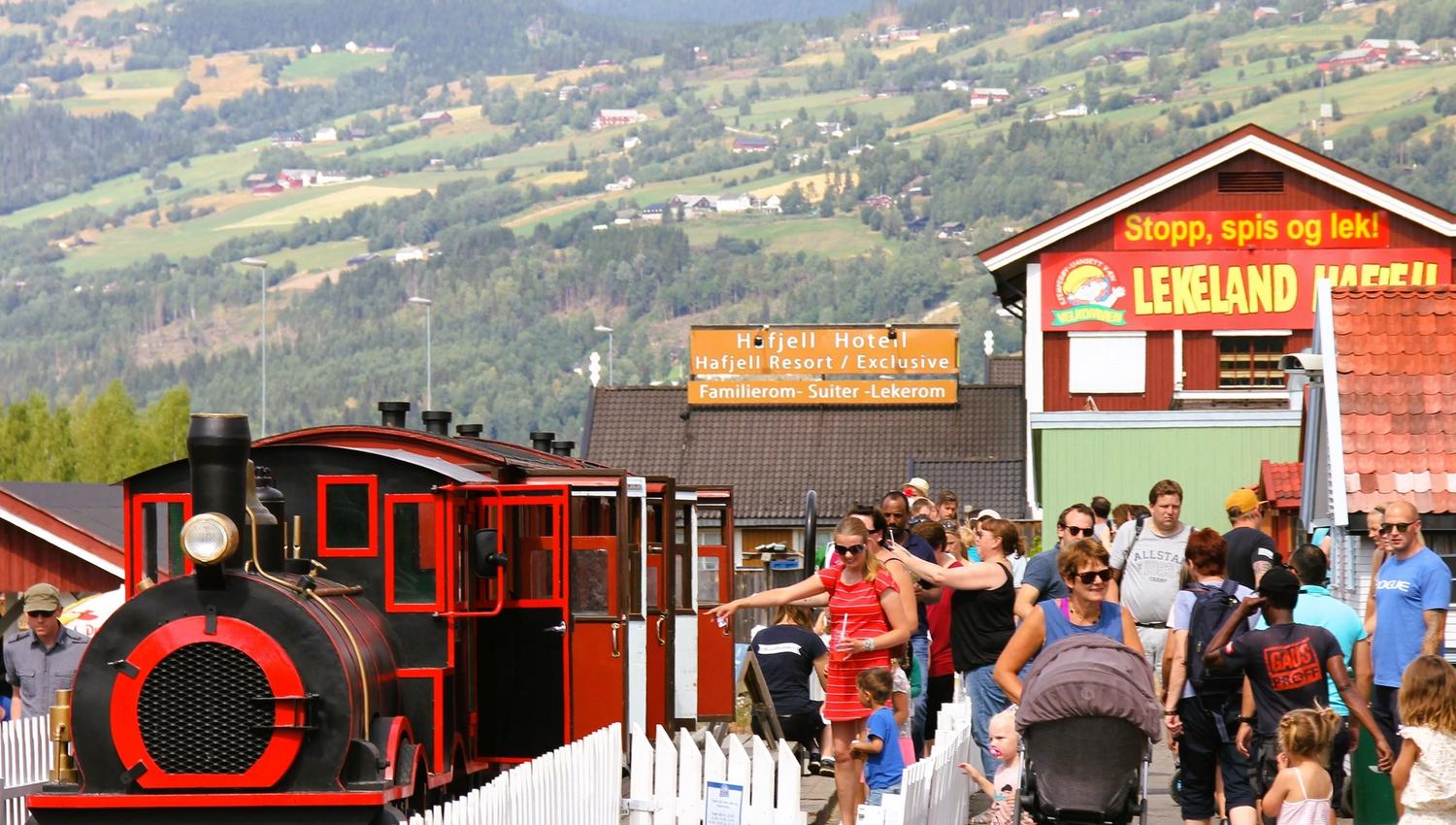 A group of people walking past a train.