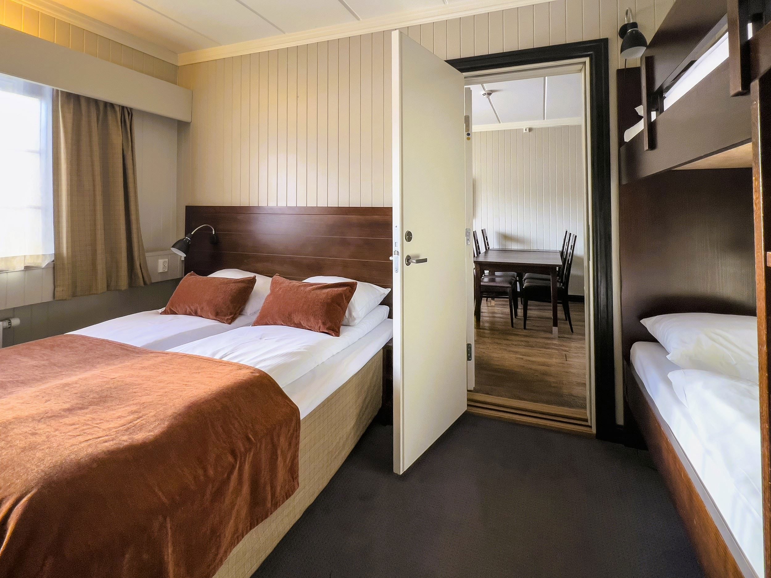 A room with two beds and an open door.