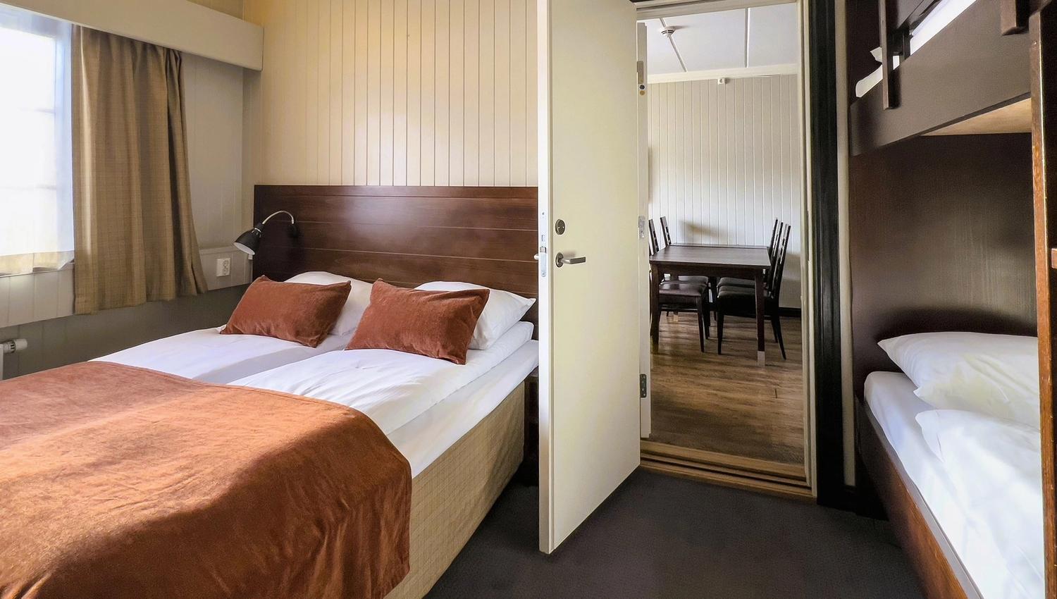 A room with two beds and an open door.