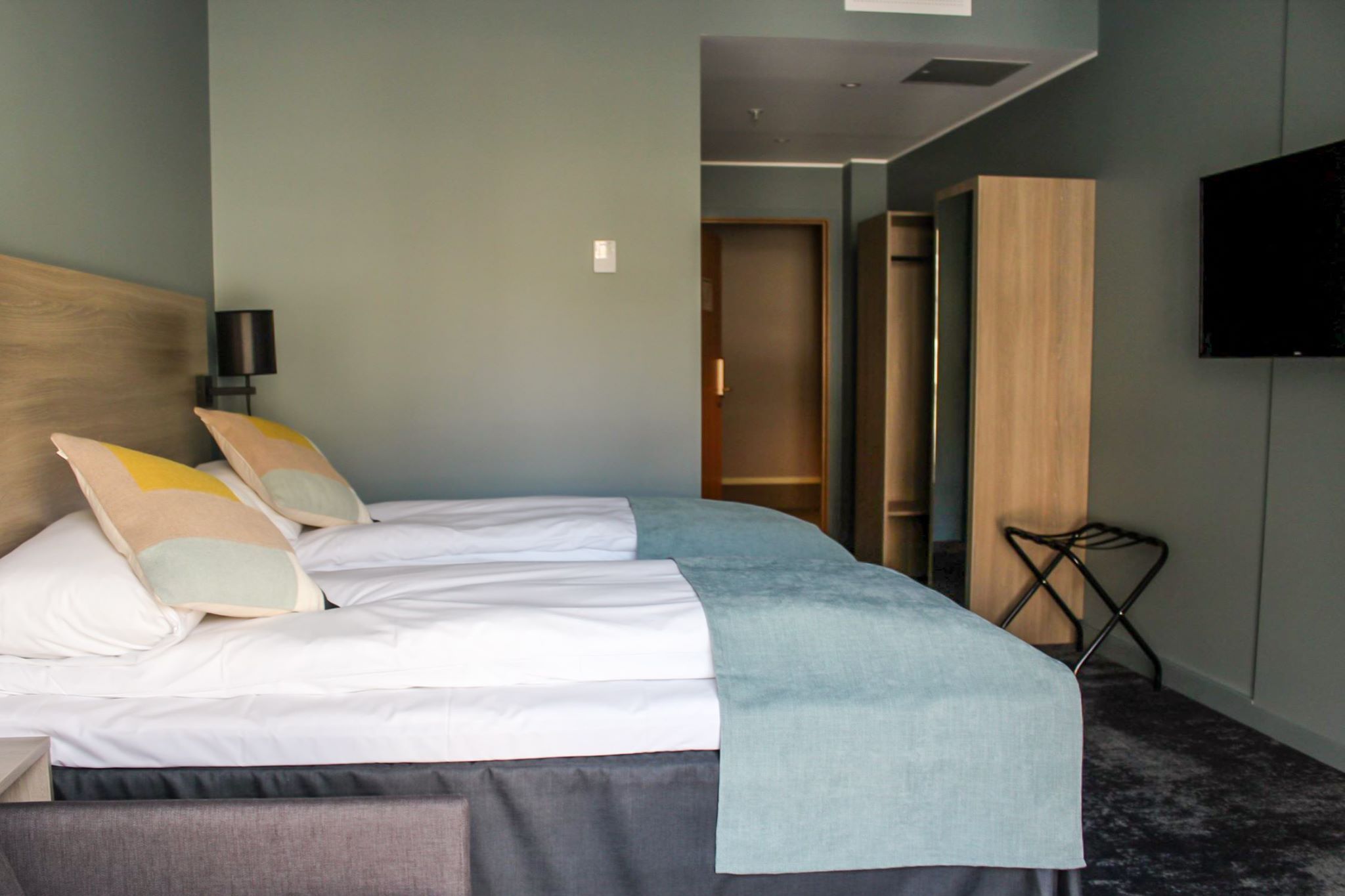Standard hotellrom med enkeltsenger, TV og praktisk oppbevaring.