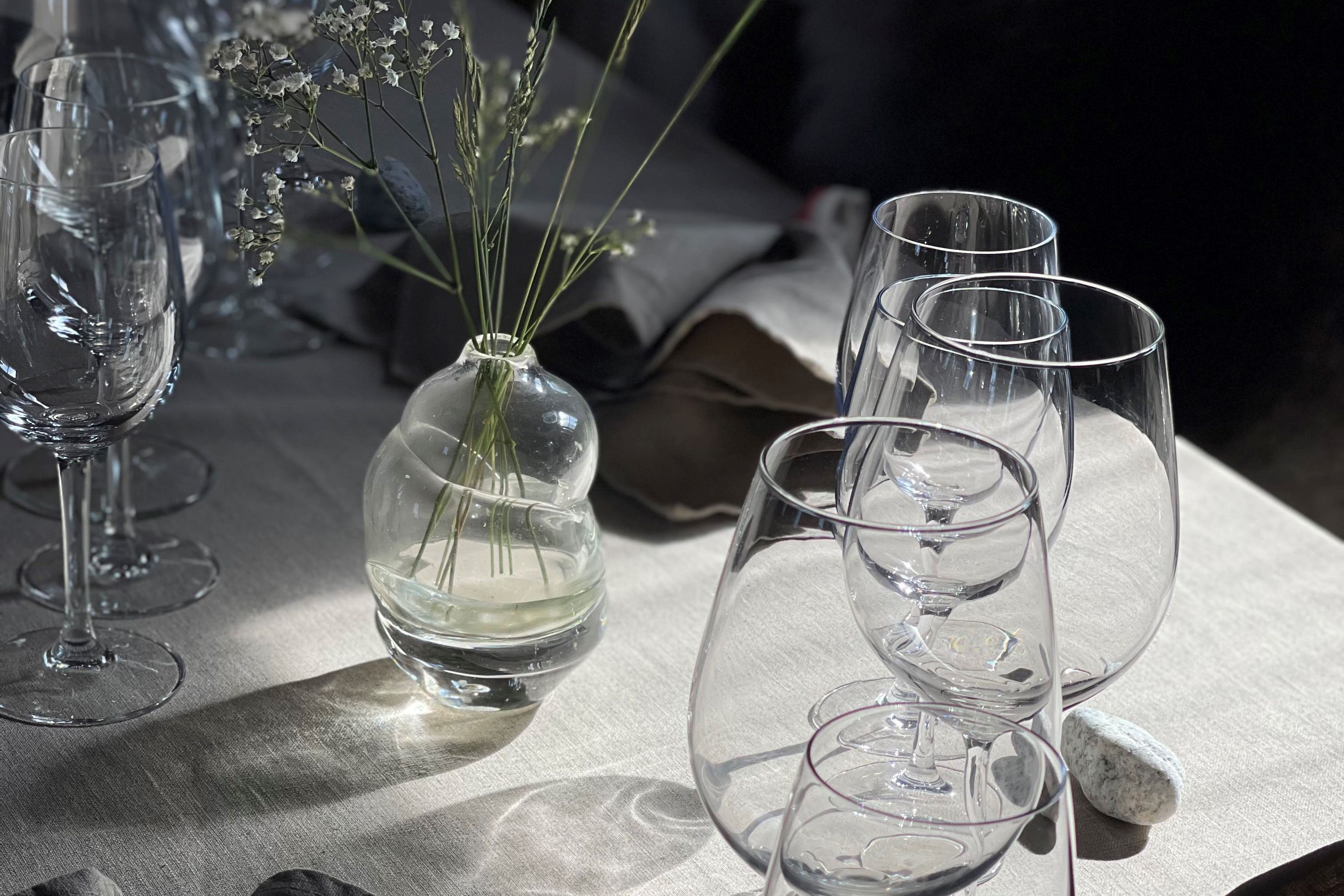 Dekket til fest med fine blomster og glass.