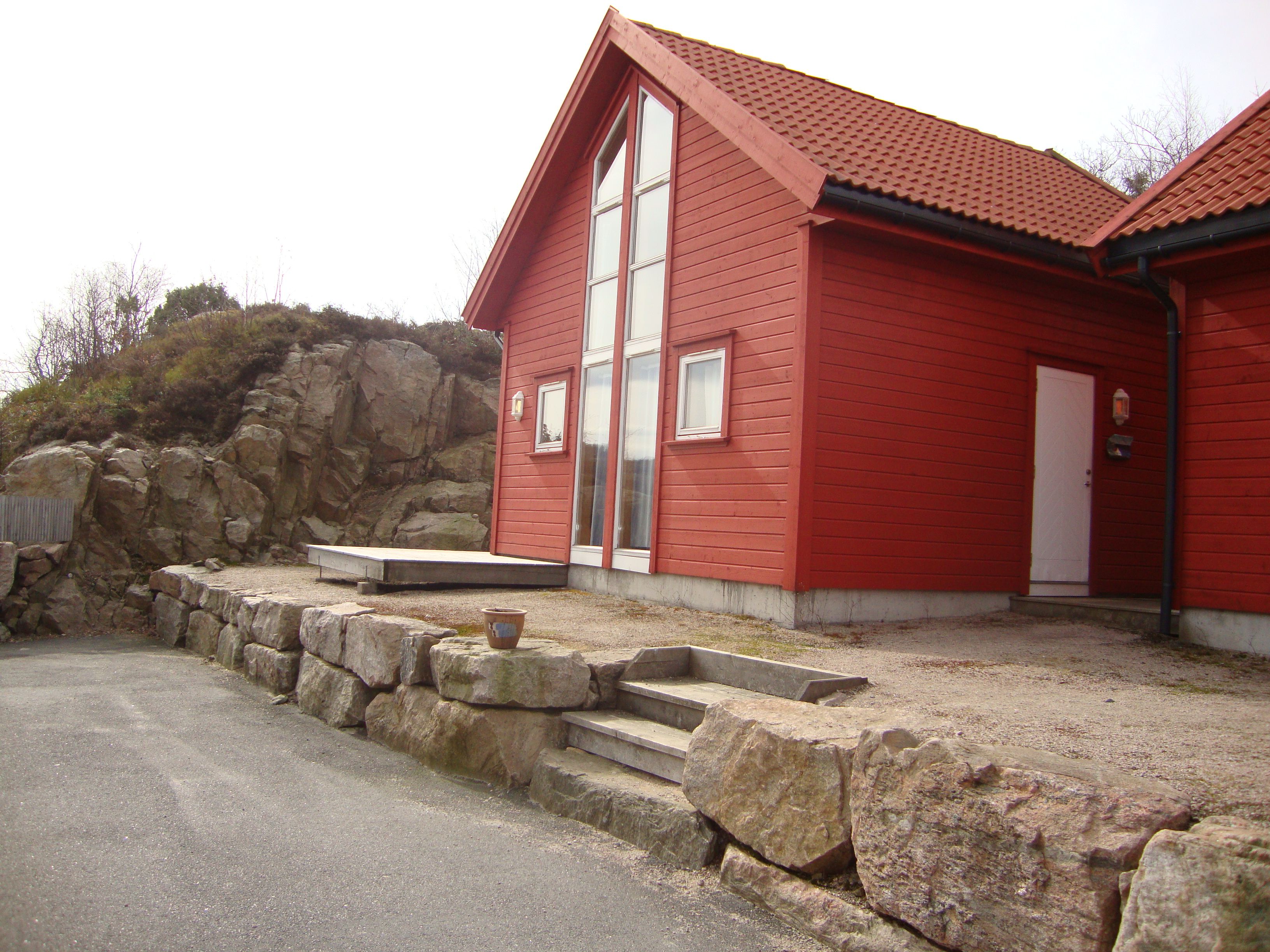 Rød hytte med steinplatting foran
