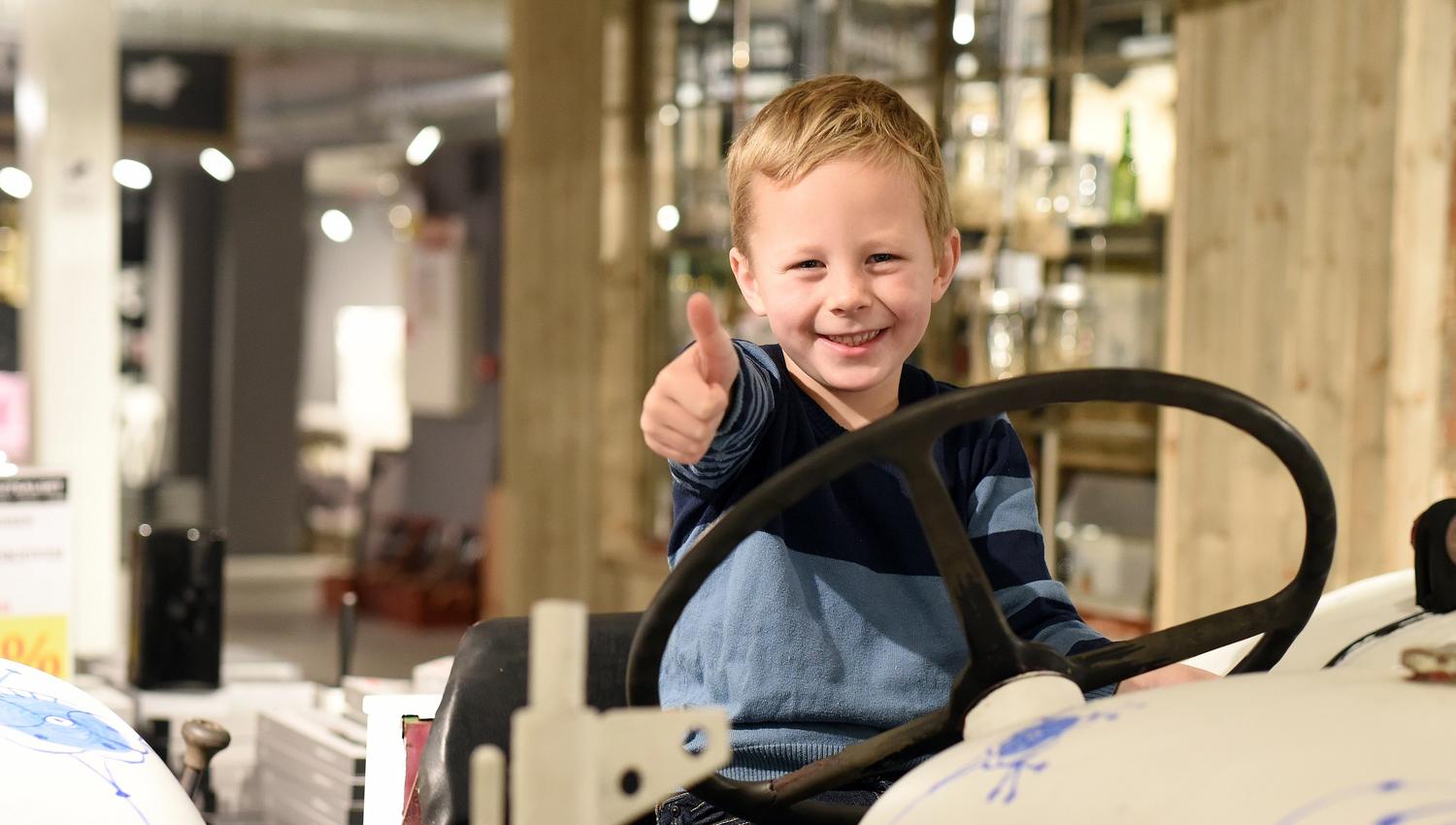little boy sitting on a porcelain car at Porsgrund's Porcelain Factory