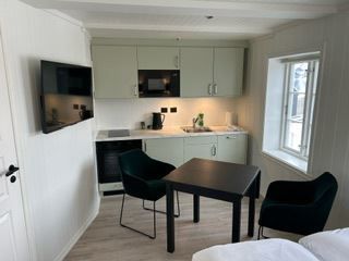 koselig kjøkken krok med tv og spise bord til to på Finsnes Gaard