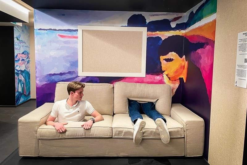 Beige sofa med en gutt som stikker ut gjennom et hull i setet, med et par bein som stikker ut ved siden av han.