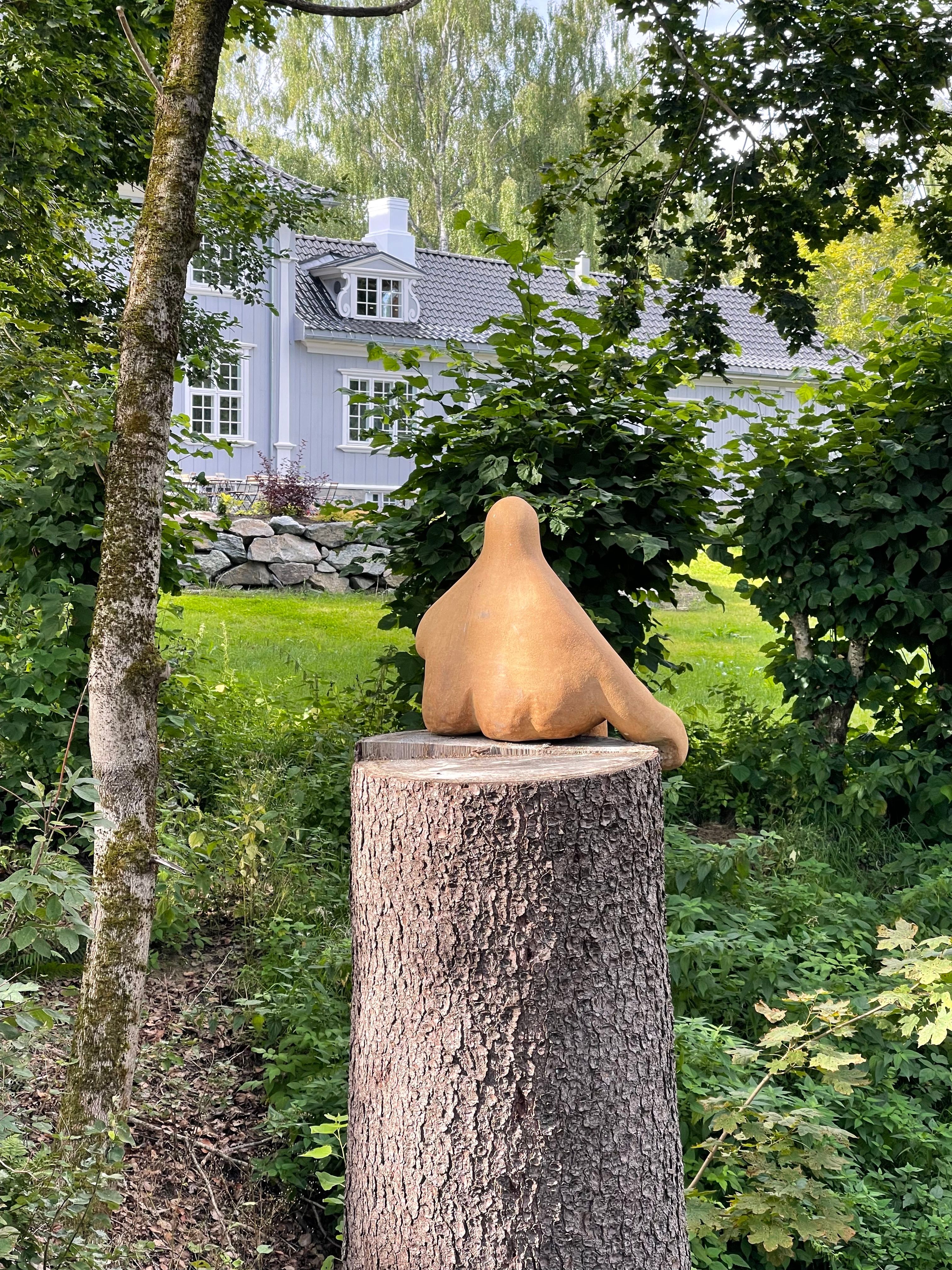 Kunst på en avkuttet tre med et hus i bakgrunnen