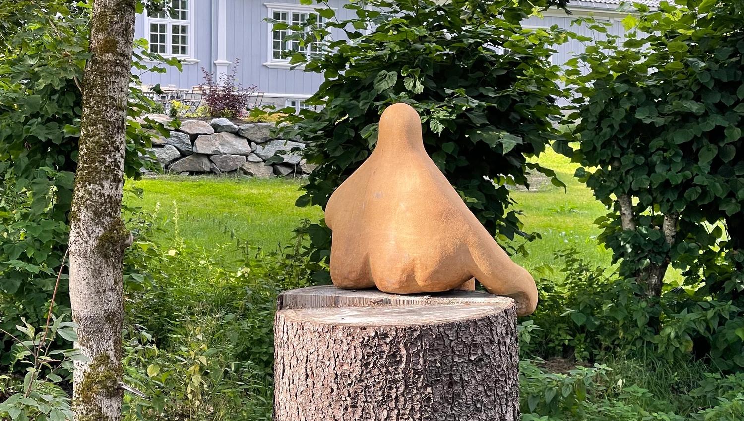 Kunst på en avkuttet tre med et hus i bakgrunnen