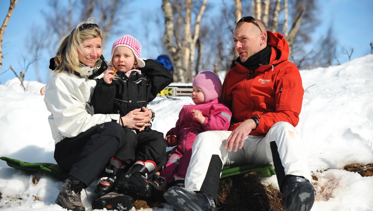 Familie som tar en pause fra skikjøringen, bilde