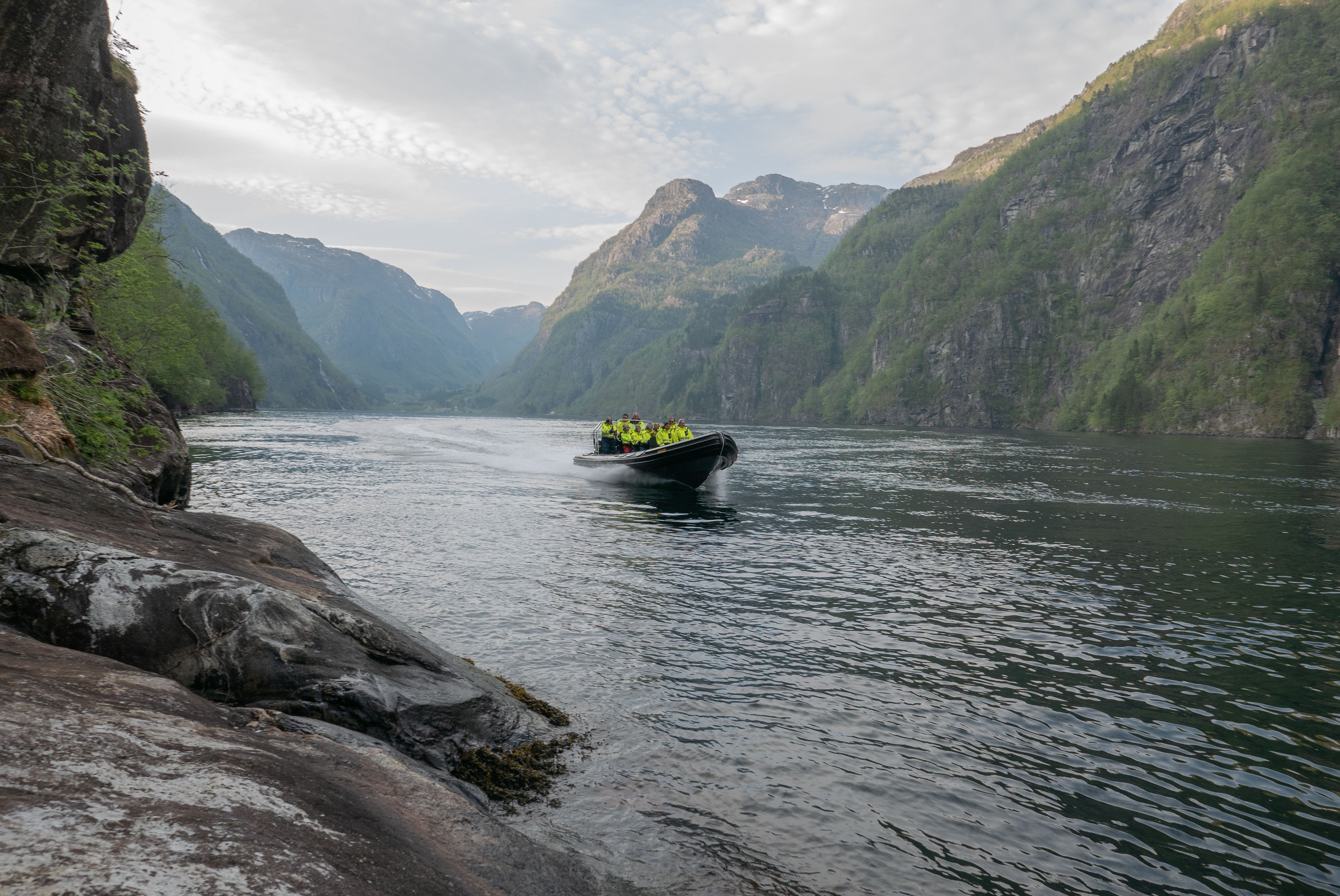 Ein RIB-båt glir gjennom den dramatiske fjordnaturen i Hardanger, ei uforgløymeleg oppleving.