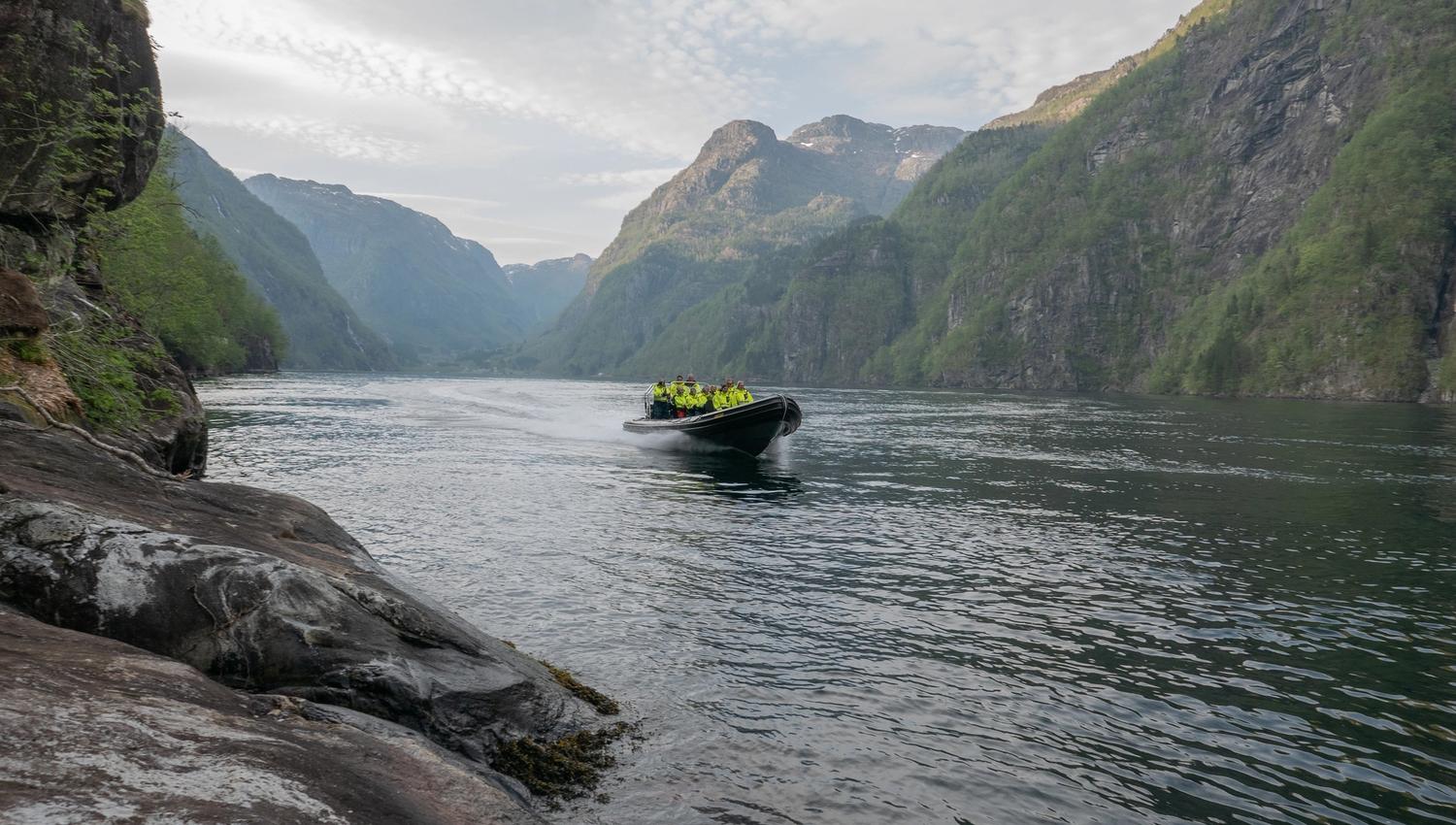 Ein RIB-båt glir gjennom den dramatiske fjordnaturen i Hardanger, ei uforgløymeleg oppleving.