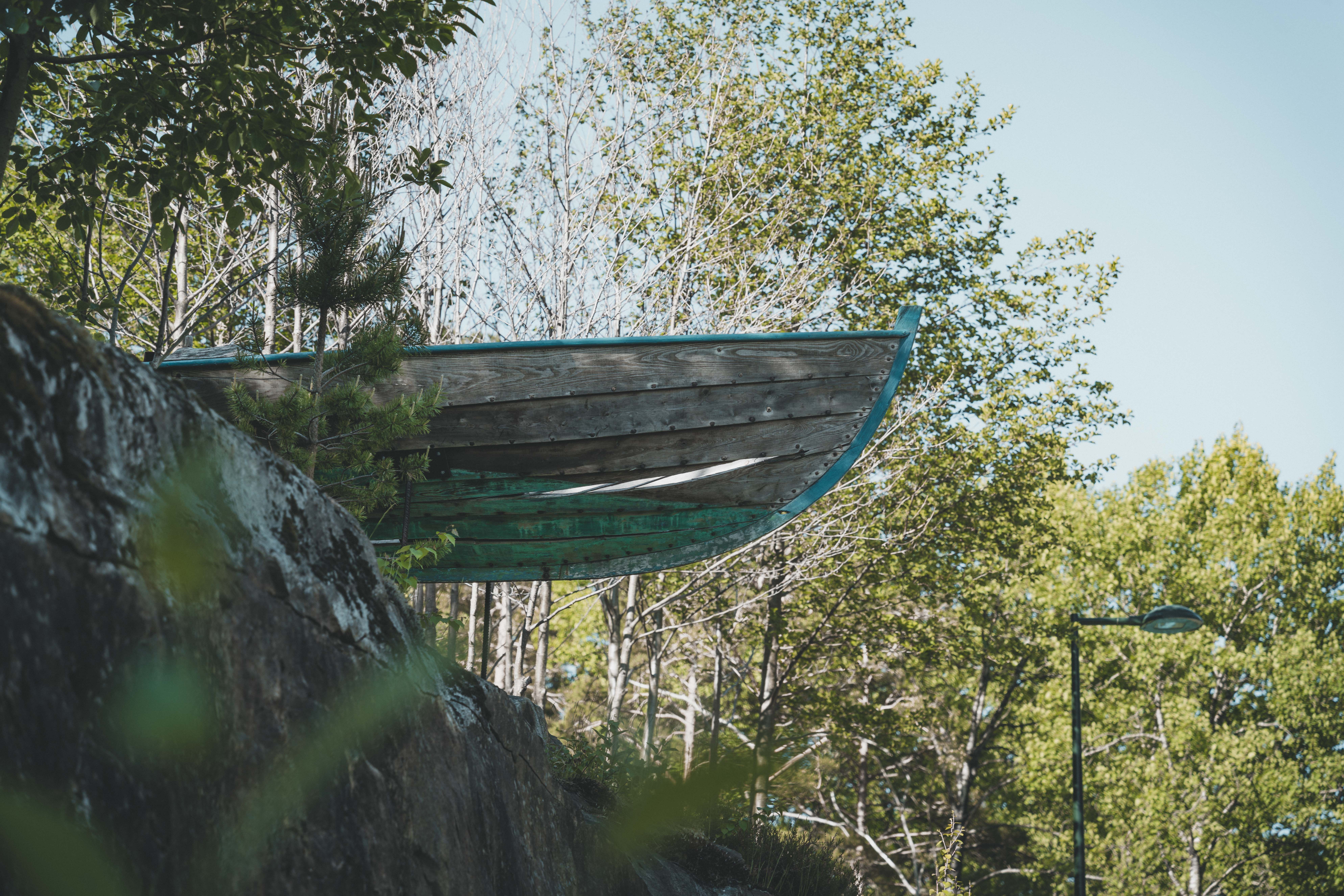 En kunstinstallasjon som viser fronten av en trebåt som stikker ut fra toppen av en ås.